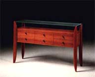 
      Consolle in tek, piano cristallo acidato.
      Teak-wood console, acidified crystal top.
      cm. 140x40 h 90
      
